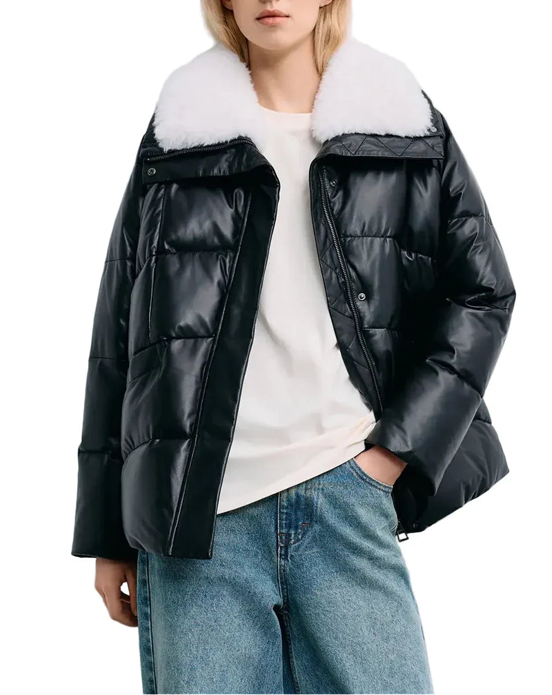 Close-up of a black leather puffer jacket with a oversized white fluffy collar and boxy fit, shown against a plain white background.