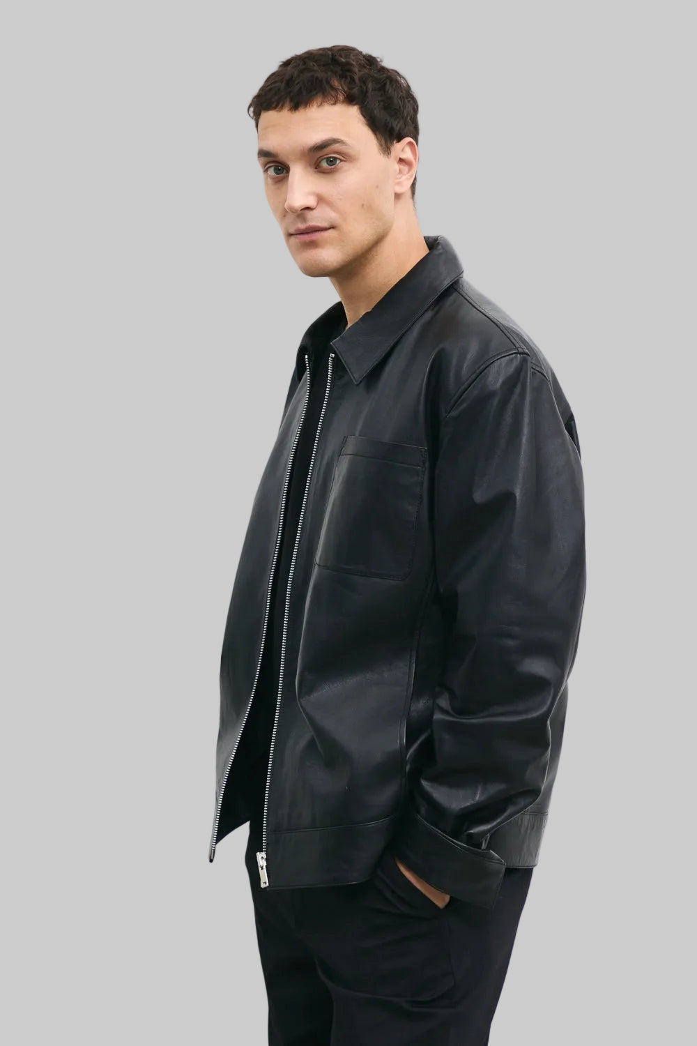 LEFT SIDE POSE Men's black leather jacket made from premium full grain leather with front zipper closure, classic collar, and modern minimalist design by LEATHERTEXEU.