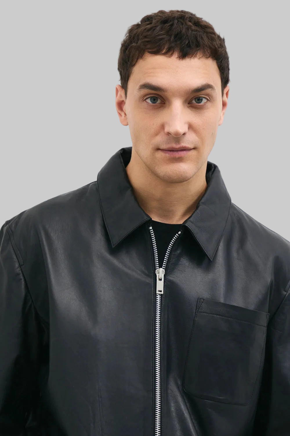 FRONT ZIP POSE Men's black leather jacket made from premium full grain leather with front zipper closure, classic collar, and modern minimalist design by LEATHERTEXEU.
